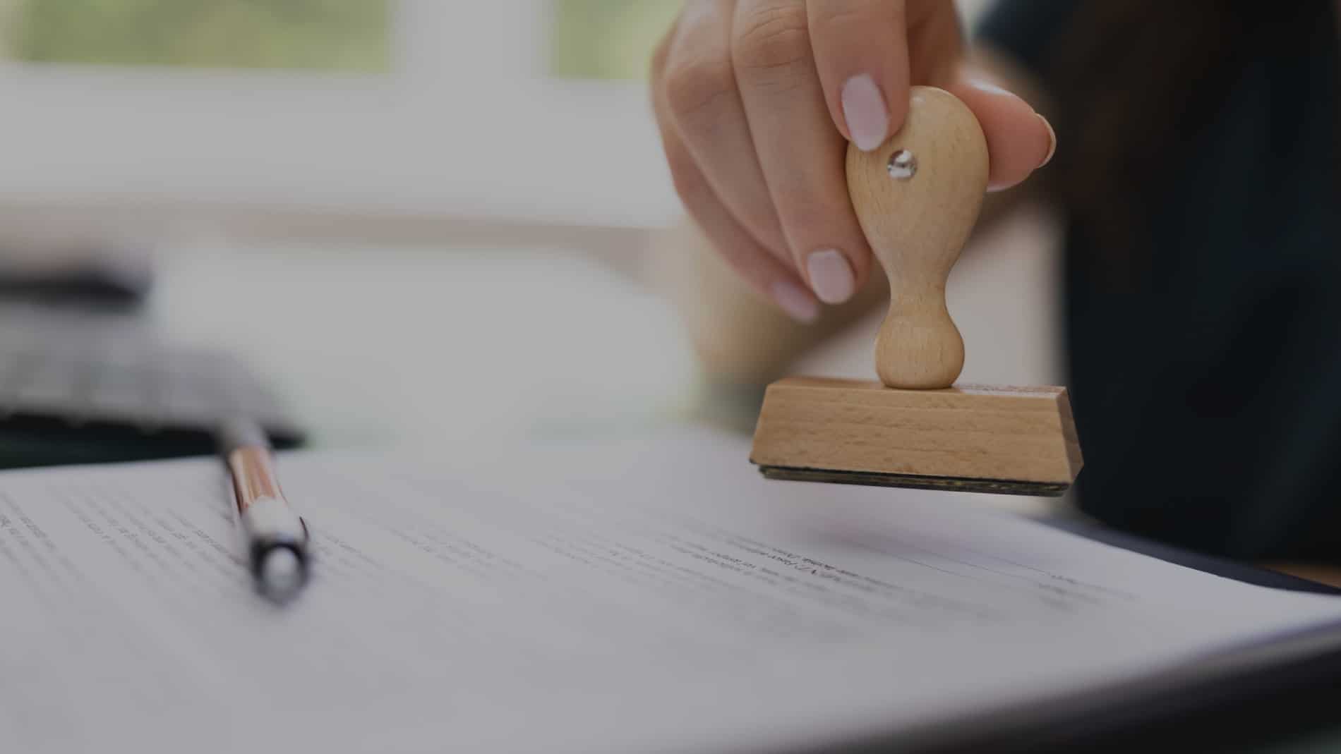 Notary applying a rubber stamp to a completed document